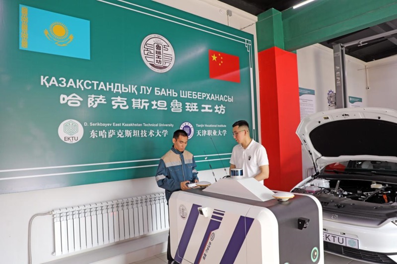 Қазақстандағы Лубань шеберханасының автомобильдерге техникалық қызмет көрсету технологияларын оқыту аймағында екі техник Қытай тарапы ұсынған интеллектуалды робот-машинаны пайдаланып сынап жатыр. Қазақстандағы Лубань шеберханасы Шығыс Қазақстан облысының орталығы Өскемен қаласында орналасқан. Жобаны Тяньцзинь кәсіптік-техникалық университеті мен Шығыс Қазақстан техникалық университеті бірлесіп салған. Оның сынақ жұмыстары 2023 жылғы 9 желтоқсанда басталды. Фото：«Халық Газеті»